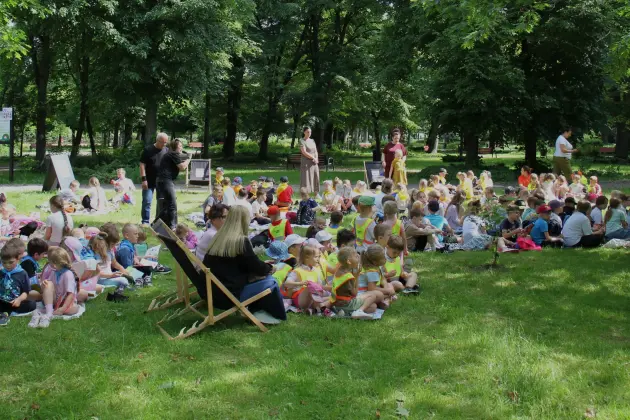 Przedszkolaki i uczniowie z książką pod chmurką w Parku Michalskiego